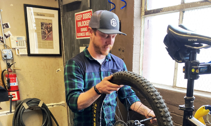 Chuck Seppanen, lead mechanic at Flagstaff Bicycle Revolution in 
Flagstaff, Arizona, works on repairing a customer's bicycle on Oct. 12.  (Allan Stein/ Pezou)
