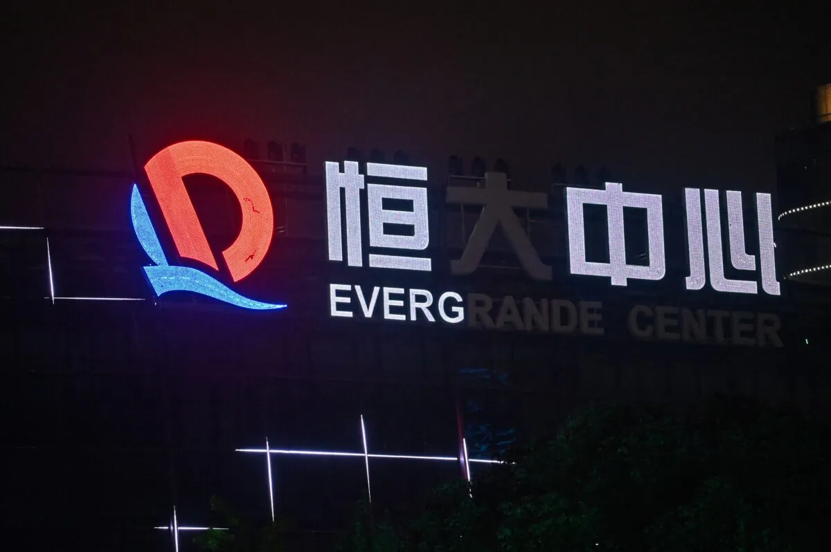 A partially illuminated sign of the Evergrande Center at the Evergrande Center building in Shanghai, China, on Oct. 9, 2021. (Hector Retamal/AFP)