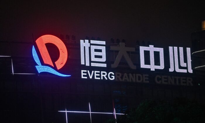 A partially illuminated sign of the Evergrande Center at the Evergrande Center building in Shanghai, China, on Oct. 9, 2021. (Hector Retamal/AFP)