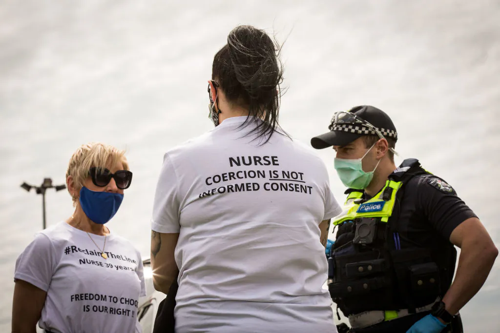 A member of Victoria Police questions a woman at Campbellfield Plaza in Melbourne, Australia, on Oct. 9, 2021. (Darrian Traynor/Getty Images)