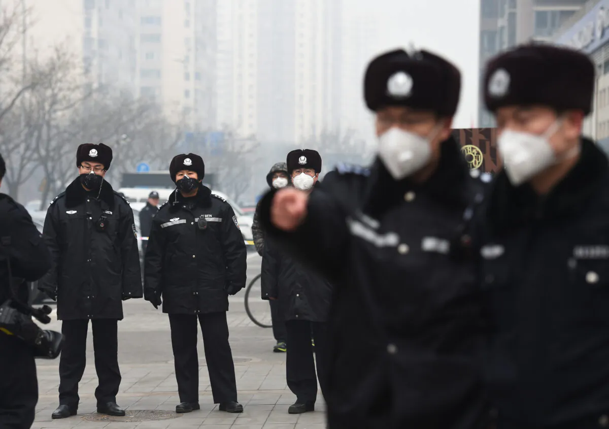 Police wear masks as they stand guard outside the No. 2 Intermediate People's Court where human rights lawyer Pu Zhiqiang was being sentenced in Beijing on Dec. 22, 2015. (Greg Baker/AFP via Getty Images)