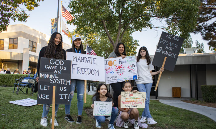 Students of PYLU School District hold up signs as parents gather to express their concerns over vaccine mandates for students at the Placentia Yorba Linda Unified School District building in Placentia, Calif., on Oct. 12, 2021. (John Fredricks/  Pezou)