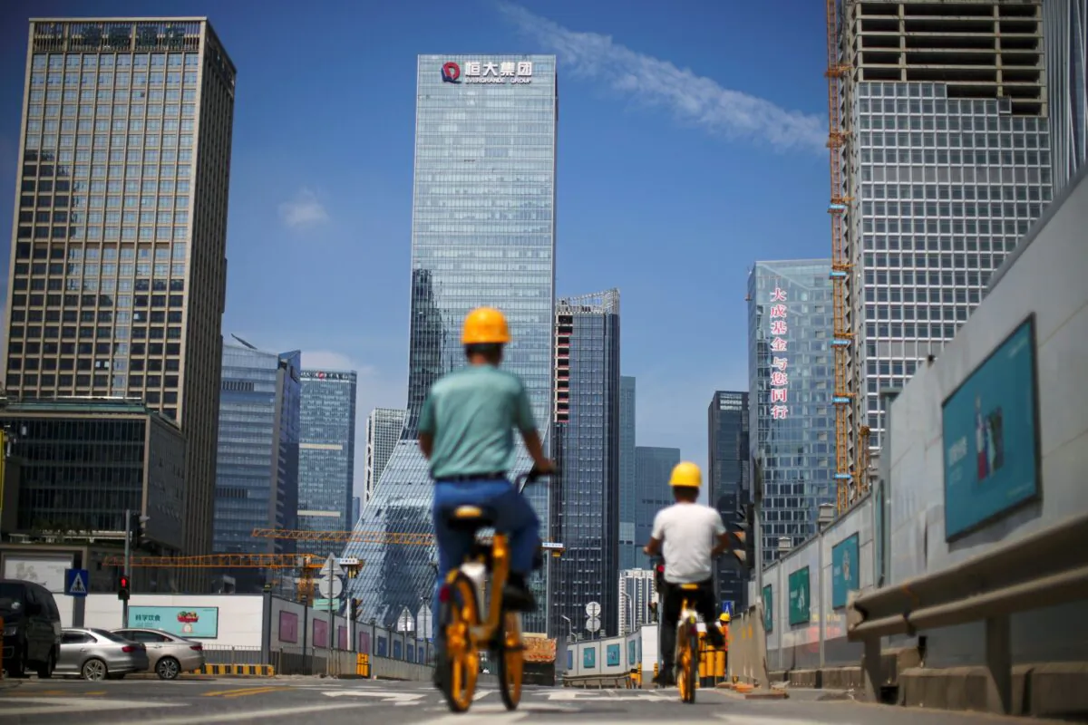 Men ride bicycles past construction sites near the headquarters of China's Evergrande Group in Shenzhen, Guangdong Province, China, on Sept. 26, 2021. (Reuters/Aly Song)