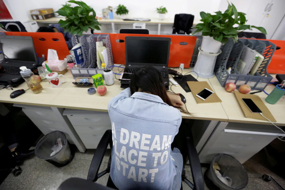 Yang Juan, an employee at Goopal Group, takes a nap in her seat after lunch, in Beijing, China, on April 21, 2016. (Jason Lee/Reuters)