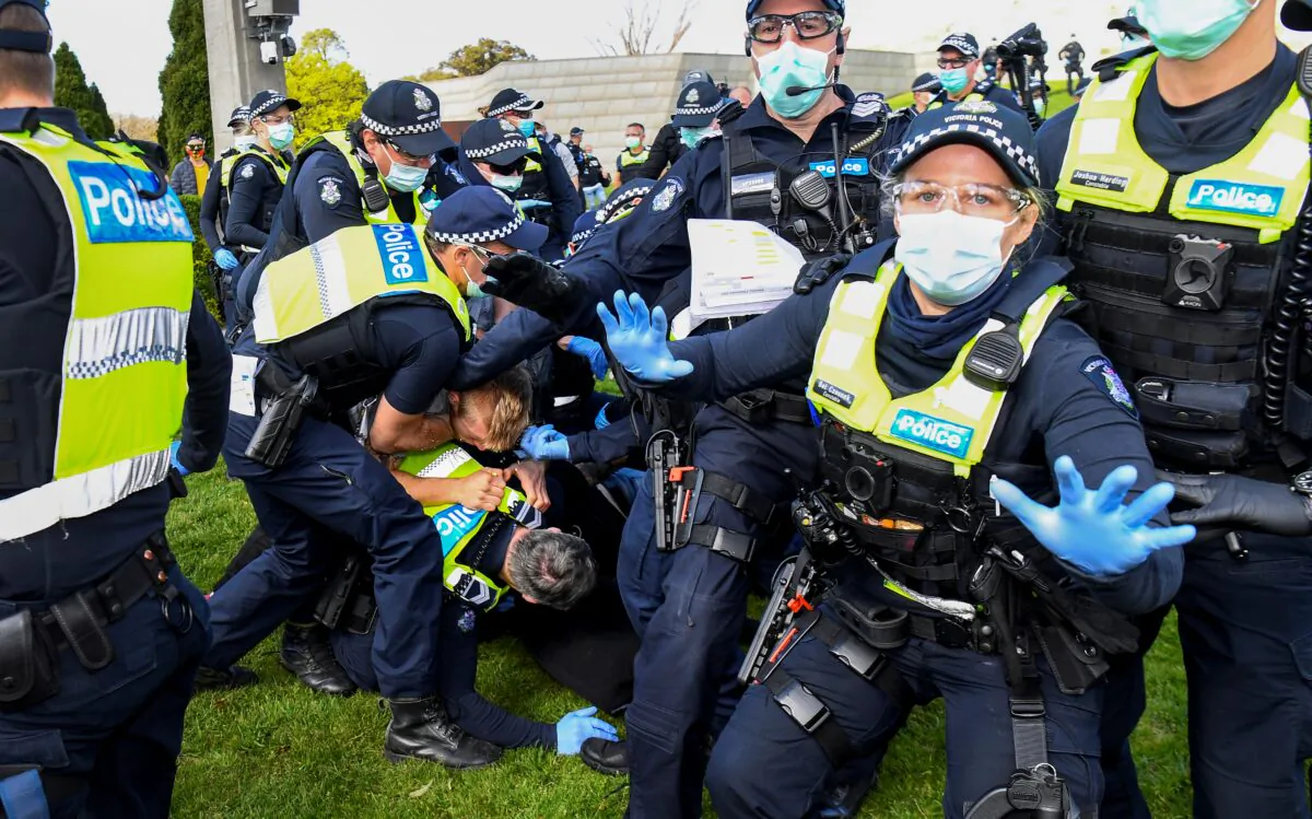 Police tackle demonstrators during a rally protesting the state's strict lockdown laws, in Melbourne, Australia, on Sept. 5, 2020. (WILLIAM WEST/AFP via Getty Images)