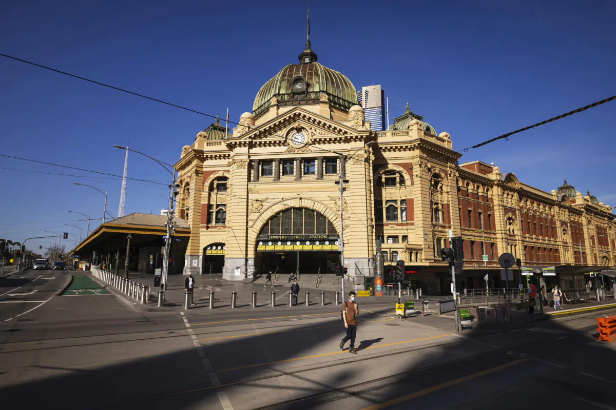 People cross a quiet Flinders Street in Melbourne on Sept. 1, 2021. (Daniel Pockett/Getty Images)
