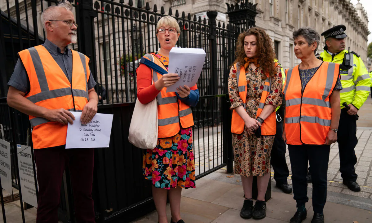 A member of Insulate Britain reads a letter to Prime Minister Boris Johnson before attempting to hand it in at 10 Downing Street, London, on Oct. 14, 2021. (Aaron Chown/PA)