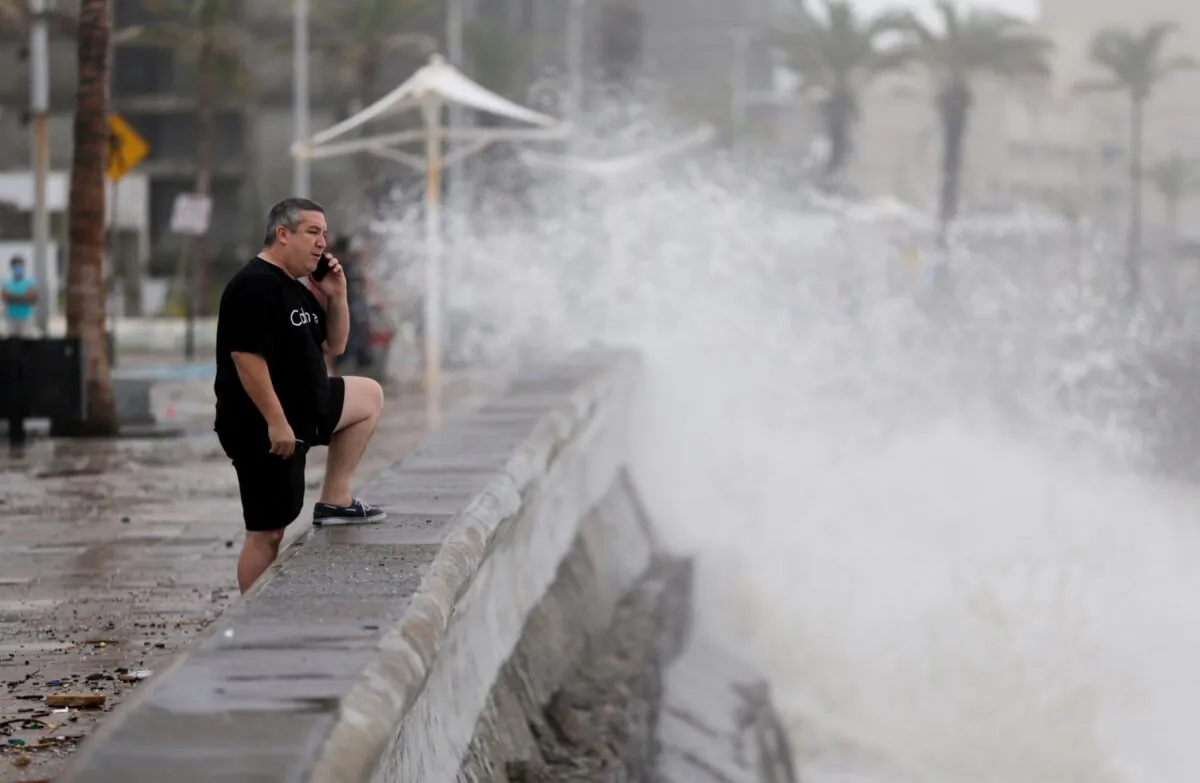 A man speaks on his mobile phone as hurricane Pamela pounds the Pacific coast resort with strong winds as it makes landfall in Mazatlan, Mexico, on Oct. 13, 2021. (Daniel Becerril/Reuters)
