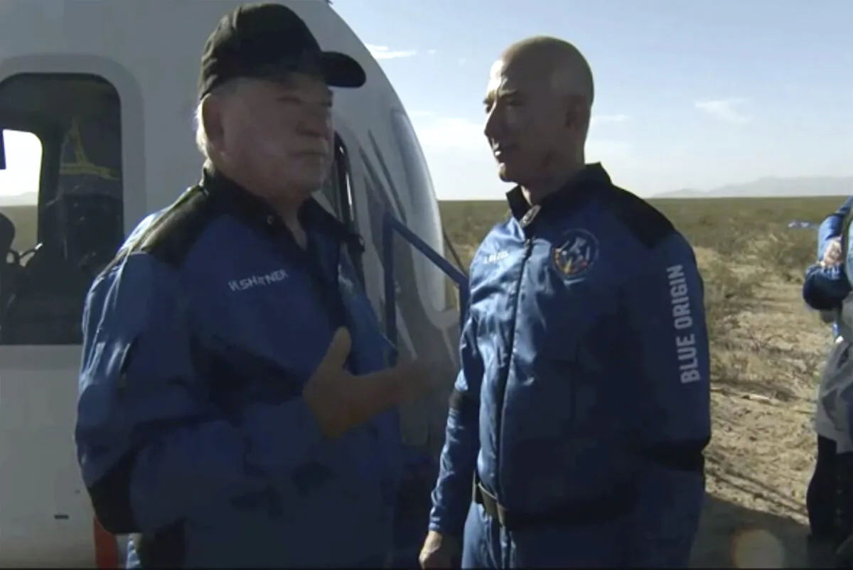 William Shatner talks with Jeff Bezos about his experience after exiting the Blue Origin capsule near Van Horn, Texas, on Oct. 13, 2021. (Blue Origin via AP)