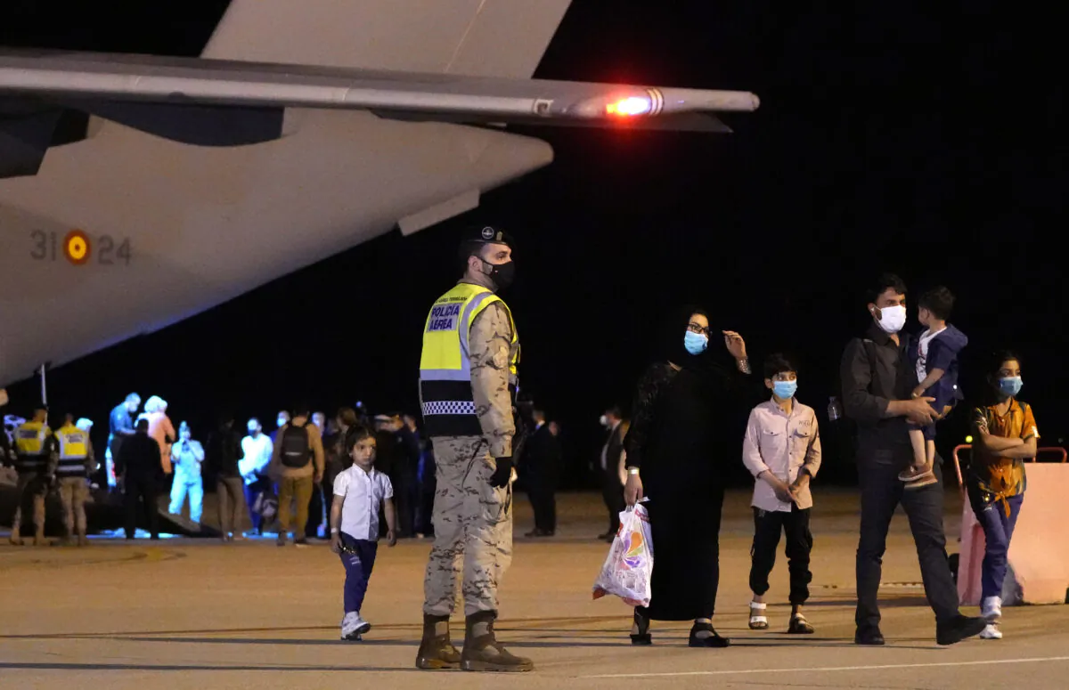 Afghan people who were transported from Islamabad walk after disembarking a plane, at the Torrejon military base in Spain on Oct. 11, 2021. (Manu Fernandez/AP Photo)