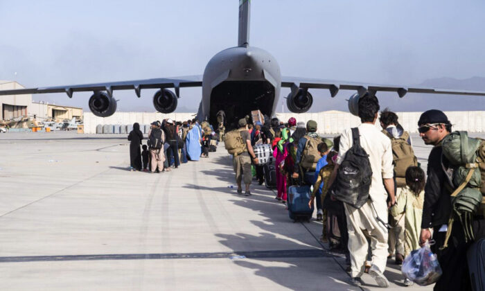 In this image provided by the U.S. Air Force, U.S. Air Force loadmasters and pilots, assigned to the 816th Expeditionary Airlift Squadron, load people being evacuated from Afghanistan onto a U.S. Air Force C-17 Globemaster III at Hamid Karzai International Airport in Kabul, Afghanistan, on Aug. 24, 2021. (Master Sgt. Donald R. Allen/U.S. Air Force via AP)
