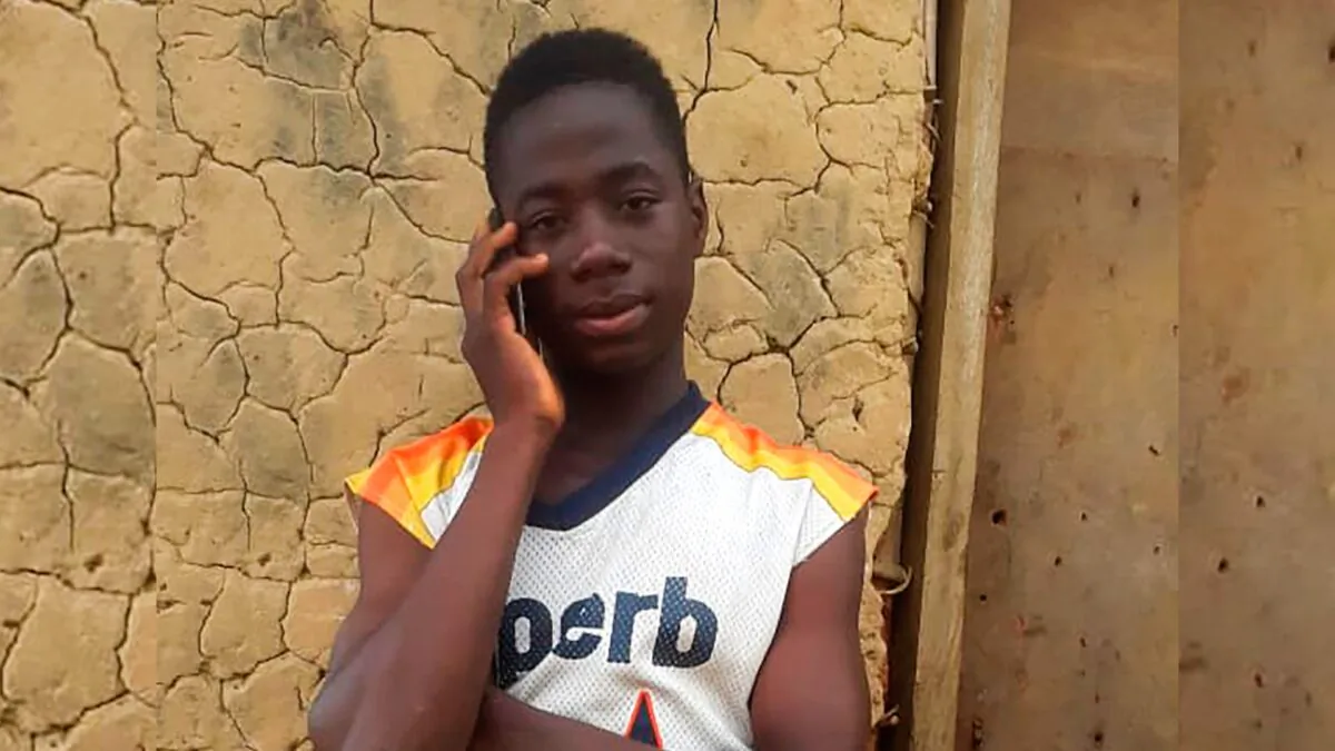 Emmanuel Tuloe, who has become a national hero in Liberia after finding $50,000 and returning it to its rightful owner, speaks on his phone in Gbolor Dialla, Liberia, on Oct. 14, 2021. (Anthony Duo/AP Photo)