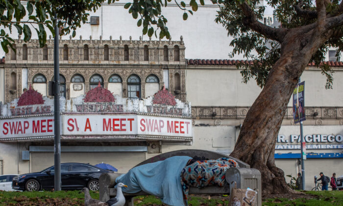 A homeless person sleeps at MacArthur Park Los Angeles, California on March 19, 2020. (APU GOMES/AFP via Getty Images)