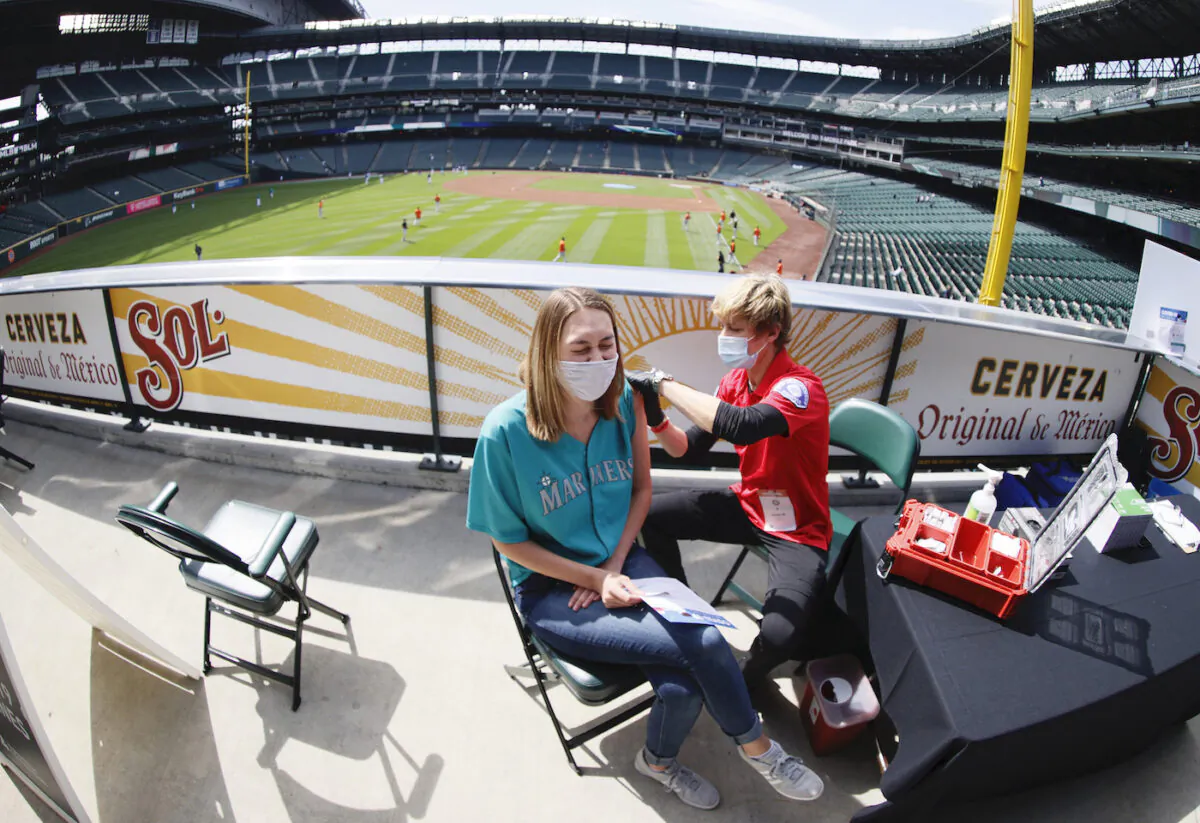 Aeryal Thomsen of Lake Stevens, Wash. receives her COVID-19 vaccination from Kristine Gill, with the Seattle Fire Department’s Mobile Vaccination Teams, before the game between the Seattle Mariners and the Baltimore Orioles at T-Mobile Park in Seattle, Wash. on May 5, 2021. (Steph Chambers/Getty Images)