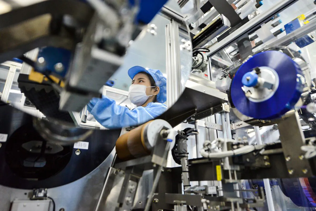 A worker’s reflection on a mirror framing a lithium-ion battery production line at a plant in Huzhou, China, owned by Microvast Holdings, whose Texas-based subsidiary qualified to negotiate for a $200 million U.S. Department of Energy grant to build lithium batteries in the U.S. (Stringer/Reuters)