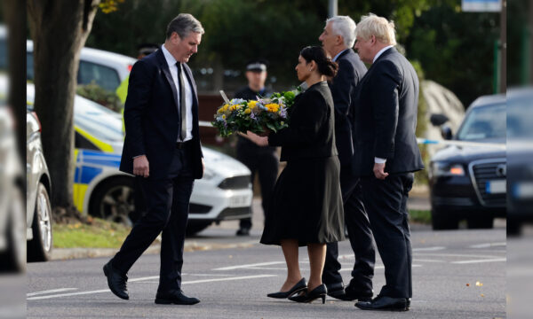 Britain’s Prime Minister Boris Johnson (R), Britain’s main opposition Labour Party leader Keir Starmer (L), Speaker of the House Lindsay Hoyle (2R), and Britain’s Home Secretary Priti Patel (2L) lay floral tributes as at the scene of the fatal stabbing of Conservative British lawmaker David Amess at Belfairs Methodist Church in Leigh-on-Sea, England, on Oct. 16, 2021. (Tolga Akmen/AFP via Getty Images)
