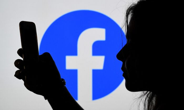 In this photo illustration, a person looks at a smart phone with a Facebook App logo displayed on the background, in Arlington, Va., on Aug. 17, 2021. (Olivier Douliery/AFP via Getty Images)