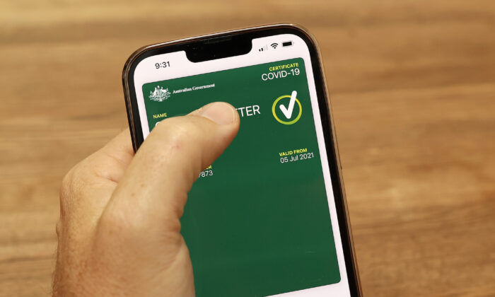 In this photo illustration a man holds a phone displaying a valid Australian digital COVID-19 vaccine certificate in Sydney, Australia, on Oct. 14, 2021. (Cameron Spencer/Getty Images)