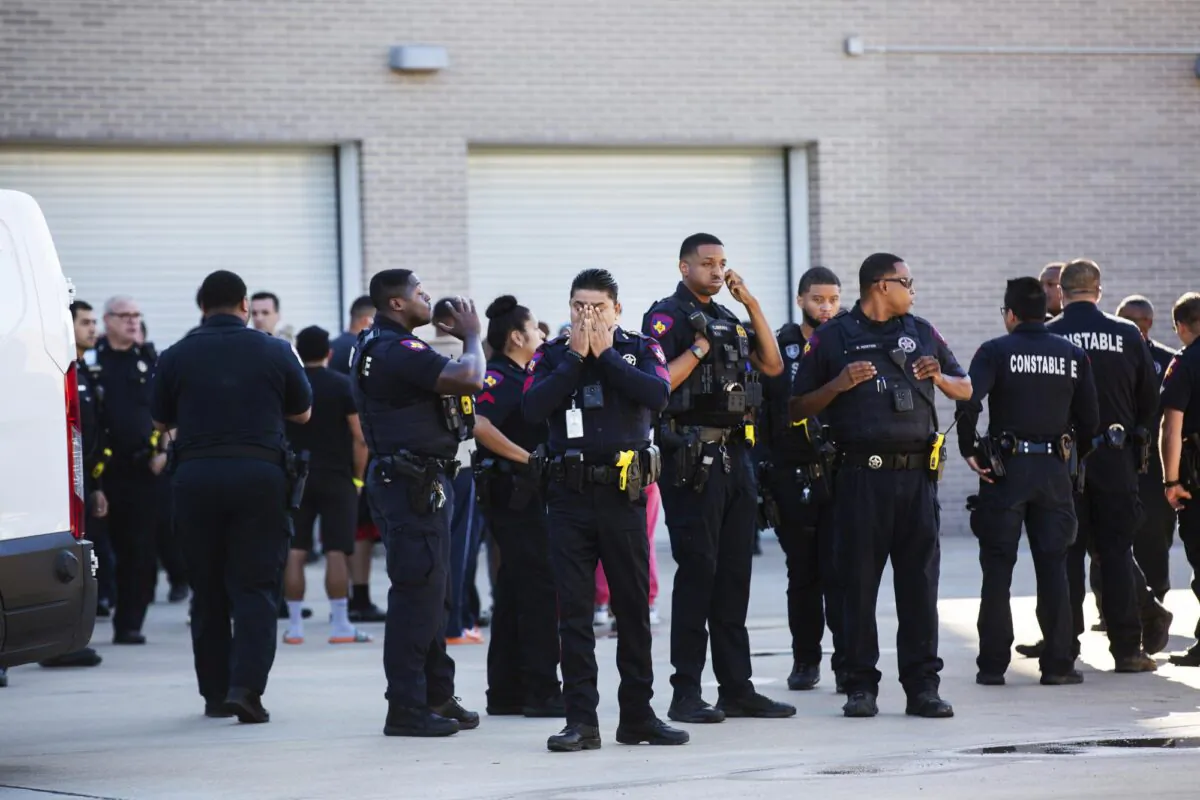 A Harris County Pct. 4 deputy covers his face after participating in a procession as the body of a fellow Harris County Pct. 4 deputy who was shot and killed in north Houston was transported to the facility, on Oct. 16, 2021. (Marie D. De Jesús/Houston Chronicle via AP)