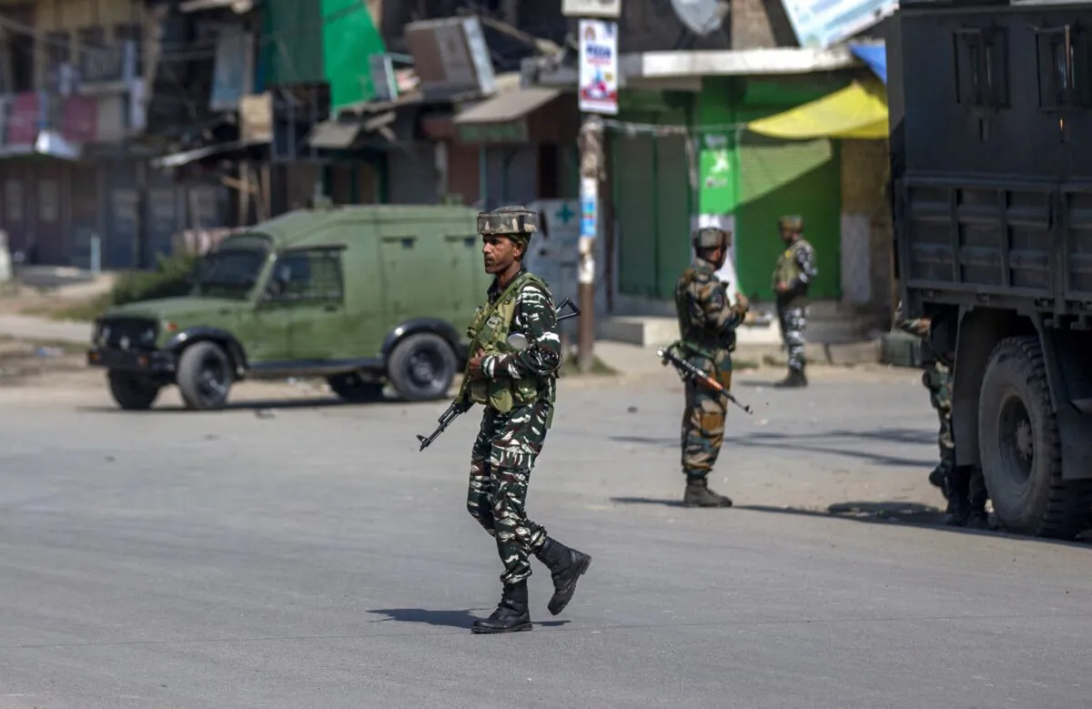 Indian paramilitary soldiers stand guard on a road leading toward the site of a gunfight in Pampore, south of Srinagar, Indian controlled Kashmir, on Oct. 16, 2021. (Dar Yasin/AP Photo)