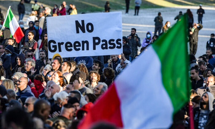 People gather during a protest against the so-called Green Pass on October 15, 2021 at Circo Massimo in Rome, as new coronavirus restrictions for workers come into effect. - Italy braced for nationwide protests, blockades and potential disruption on October 15, 2021 as all workers must show a so-called Green Pass, offering proof of vaccination, recent recovery from Covid-19 or a negative test, or face being declared absent without pay. (Photo by Tiziana FABI / AFP) (Photo by TIZIANA FABI/AFP via Getty Images)
