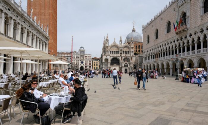 People sit at outdoor tables in St. Mark's Square, Venice, Italy, on May 16, 2021. (Manuel Silvestri/Reuters, File Photo)