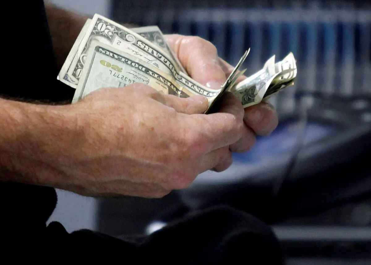A customer counts his cash at the register while purchasing an item at a Best Buy store in the borough of Queens, New York City. (Jessica Rinaldi/Reuters)