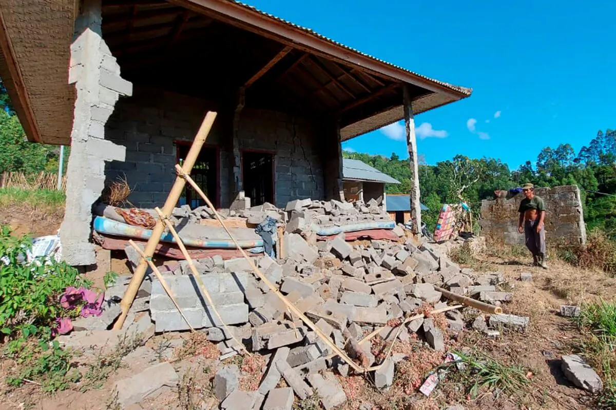 A man stands near his house damaged by an earthquake in Karangasem on the island of Bali, Indonesia on Oct. 16, 2021. (Andi Husein/AP Photo)