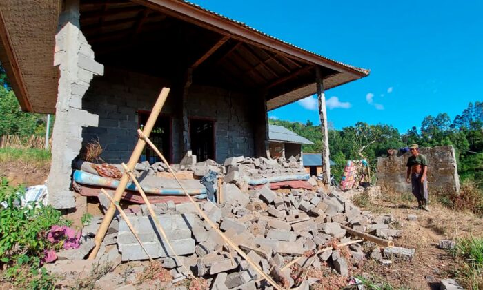 A man stands near his house damaged by an earthquake in Karangasem on the island of Bali, Indonesia on Oct. 16, 2021. (Andi Husein/AP Photo)