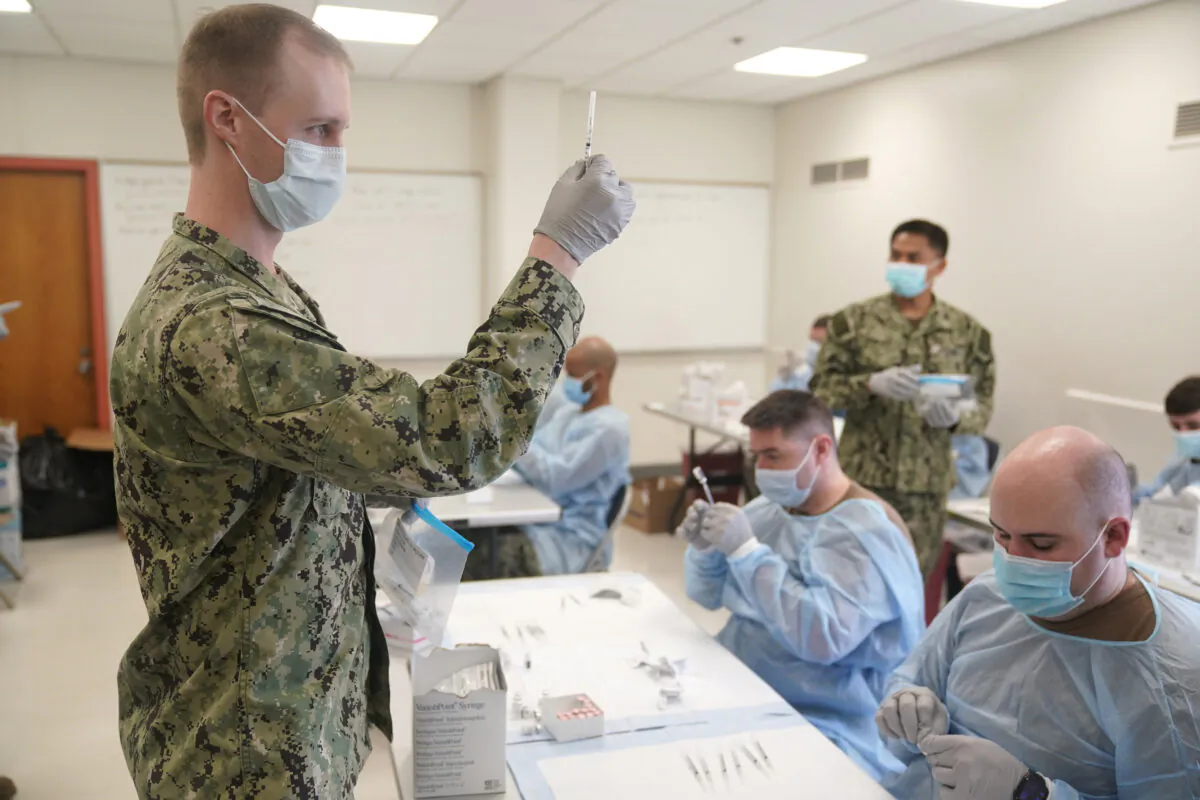 Navy personnel prepare doses of a COVID-19 vaccine at a vaccination site in New York City on Feb. 24, 2021. (Seth Wenig/Pool/AFP via Getty Images)