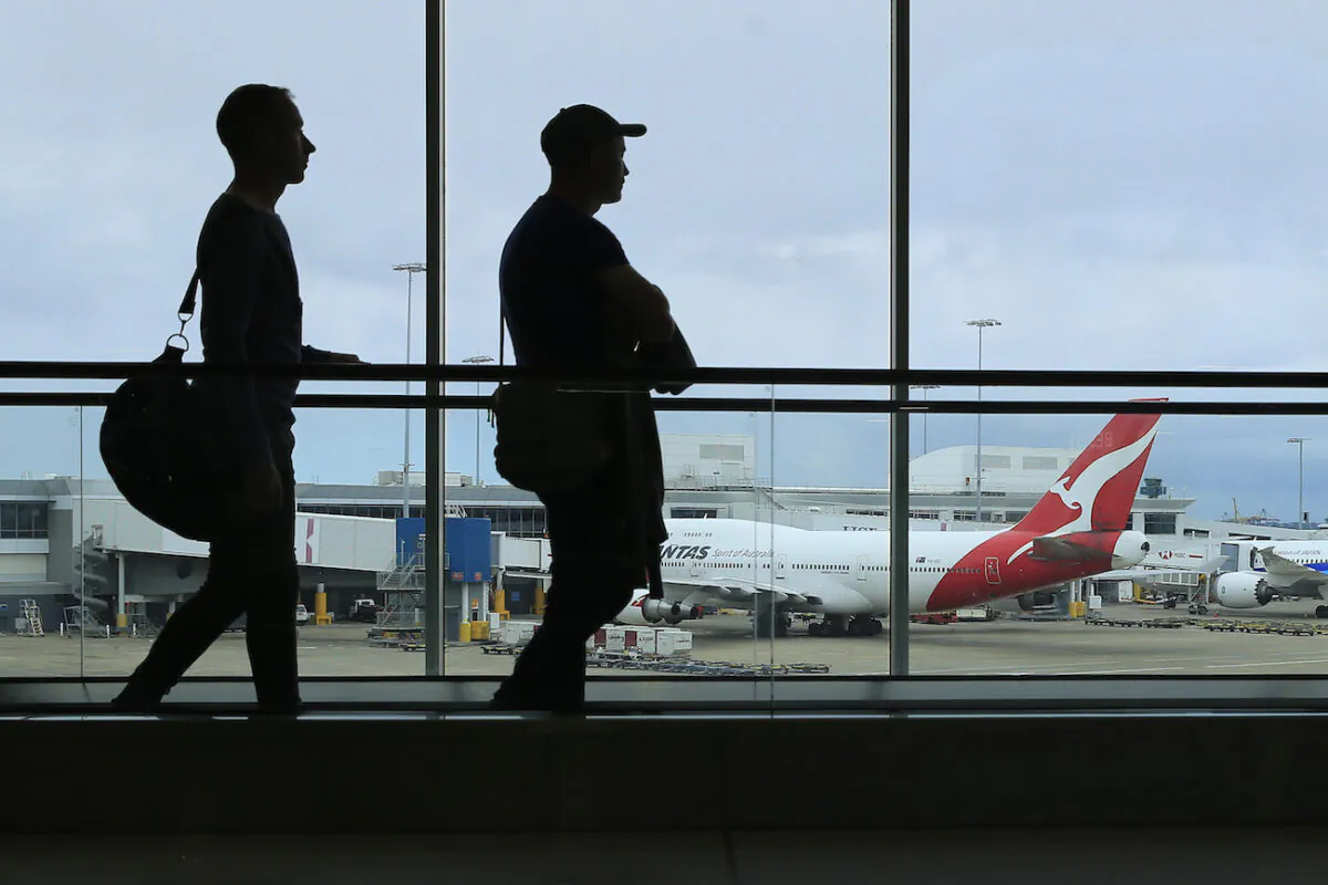 Two passengers walk past a Qantas jet at the International terminal at Sydney Airport in Sydney, Australia, on March 10, 2020. (Mark Evans/Getty Images)