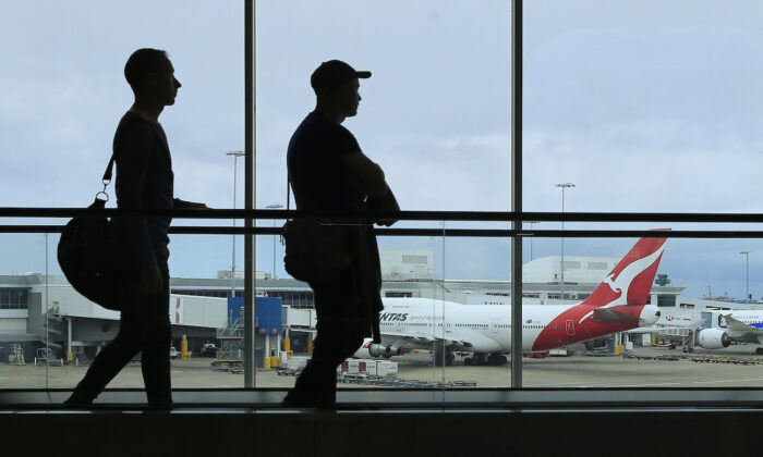 Two passengers walk past a Qantas jet at the International terminal at Sydney Airport in Sydney, Australia, on March 10, 2020. (Mark Evans/Getty Images)