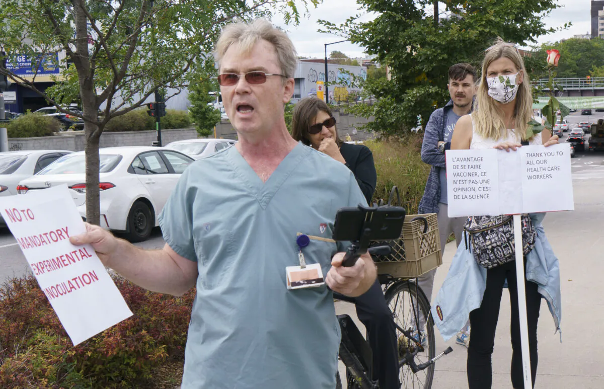 A health-care worker demonstrates against mandatory vaccination mandates as a vaccine supporter looks on in front of a hospital in Montreal, on Sept. 13, 2021. (THE CANADIAN PRESS/Paul Chiasson)