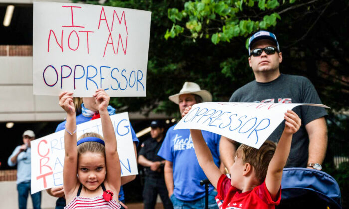 Children hold up signs during a rally against critical race theory being taught in schools at the Loudoun County Government center in Leesburg, Va., on June 12, 2021. (Andrew Caballero-Reynolds/AFP via Getty Images)