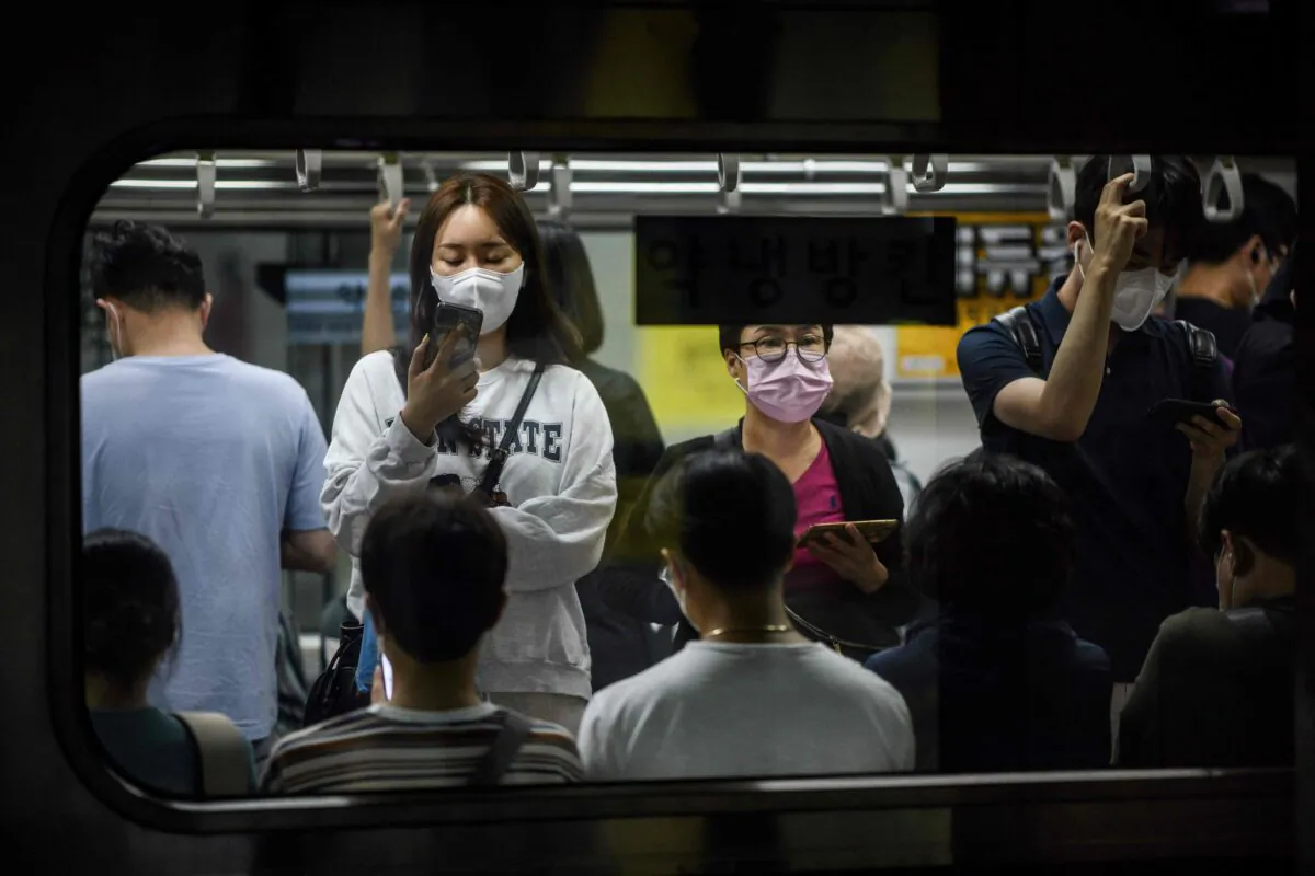 Commuters travel on an underground metro train in Seoul, South Korea, on Sept. 16, 2021. (ANTHONY WALLACE/AFP via Getty Images)
