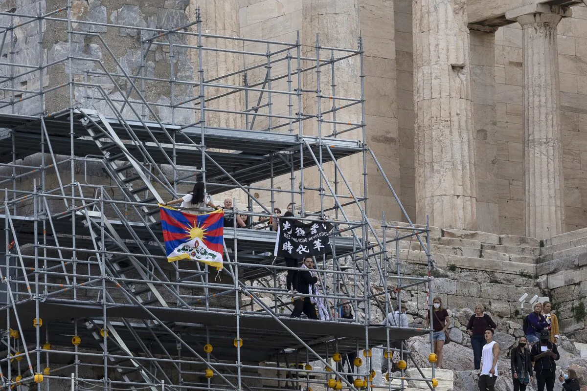Protesters raise a Tibetan flag and a banner from scaffolding at the Acropolis hill, in Athens, Greece, on Oct. 17, 2021. (Yorgos Karahalis/AP Photo)