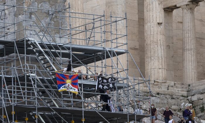 Protesters raise a Tibetan flag and a banner from scaffolding at the Acropolis hill, in Athens, Greece, on Oct. 17, 2021. (Yorgos Karahalis/AP Photo)