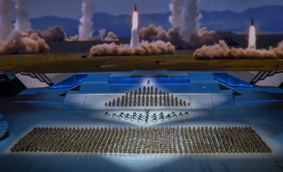 Performers dressed as military dance in front of a screen showing rockets being launched during a mass gala marking the 100th anniversary of the Communist Party at the Olympic Bird's Nest stadium in Beijing on June 28, 2021. (Kevin Frayer/Getty Images)