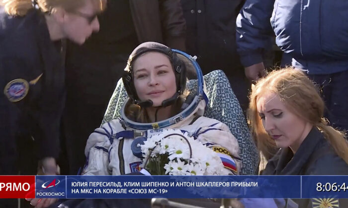 In this photo taken from video footage released by Roscosmos Space Agency, actress Yulia Peresild sits in a chair shortly after the landing of the Russian Soyuz MS-18 space capsule, southeast of the Kazakh town of Zhezkazgan, Kazakhstan, on Oct. 17, 2021. (Roscosmos Space Agency via AP)