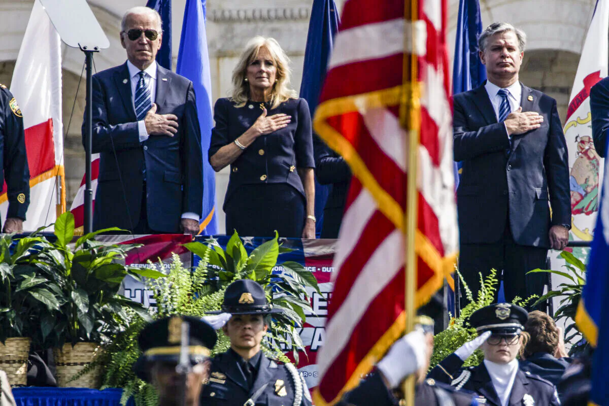 WASHINGTON, DC - OCTOBER 16: (left to right) U.S. President Joe Biden, First Lady Jill Biden, and Federal Bureau of Investigation (FBI) Director Christopher Wray stand during the U.S. National Anthem at the 40th Annual National Peace Officers’ Memorial Service on the West Front of the U.S. Capitol Building on October 16, 2020 in Washington, DC. The memorial service is being held to honor the 491 law enforcement officers who lost their lives in the line of duty in 2019 and 2020. (Photo by Samuel Corum/Getty Images)