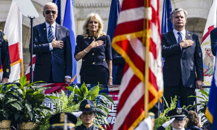 (L-R) President Joe Biden, First Lady Jill Biden, and FBI Director Christopher Wray stand during the U.S. National Anthem at the 40th Annual National Peace Officers’ Memorial Service on the West Front of the U.S. Capitol Building in Washington on Oct. 16, 2021. (Samuel Corum/Getty Images)