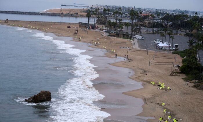 Workers in protective suits clean the contaminated beach in Corona Del Mar after an oil spill in Newport Beach, Calif., on Oct. 7, 2021. (Ringo H.W. Chiu/AP Photo)