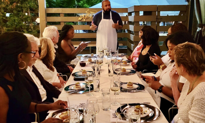 Chef Martin Draluck explains the significance of their meal to participants at a "Hemings & Hercules" dinner at Post and Beam in Los Angeles. 