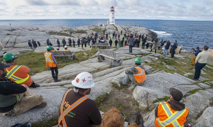 Construction workers look on at  the opening of a new viewing deck in Peggy's Cove, N.S. on Oct. 18, 2021.  1,300 square-metre deck provides accessible public space overlooking the iconic lighthouse. ( Canadian Press/Andrew Vaughan)