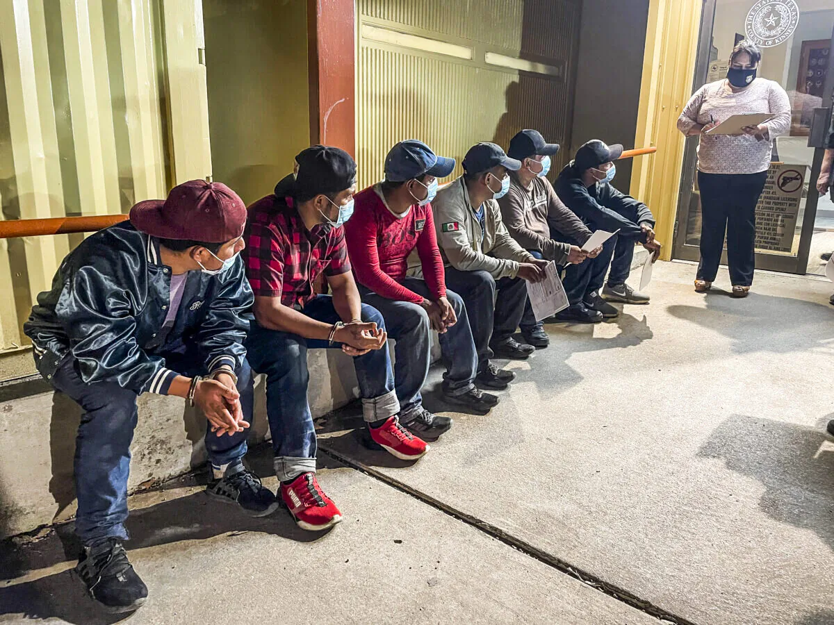 Kinney County Justice of the Peace Narce Villarreal (R) magistrates a group of illegal immigrants from Mexico as they’re charged for criminal trespass on a local ranch, at the Kinney County Sheriff's Office in Brackettville, Texas, on Aug. 8, 2021. (Charlotte Cuthbertson/The Epoch Times)
