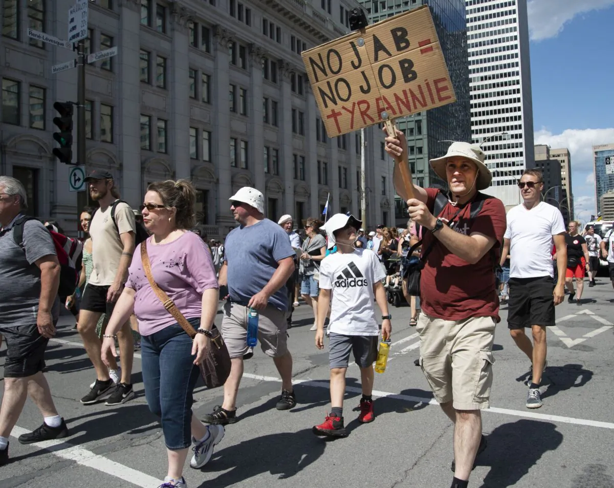 Protesters march against Quebec’s decision to impose a vaccine passport system across the province starting Sept. 1, in Montreal on Aug. 14, 2021. (The Canadian Press/Peter McCabe)