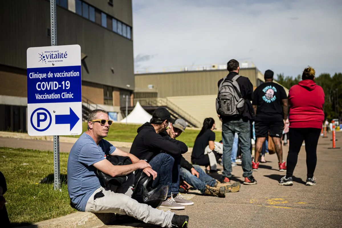 People wait in line at a mass vaccination and testing clinic at the Moncton Coliseum in Moncton, N.B., on Sept. 22, 2021. (The Canadian Press/Christopher Katsarov)