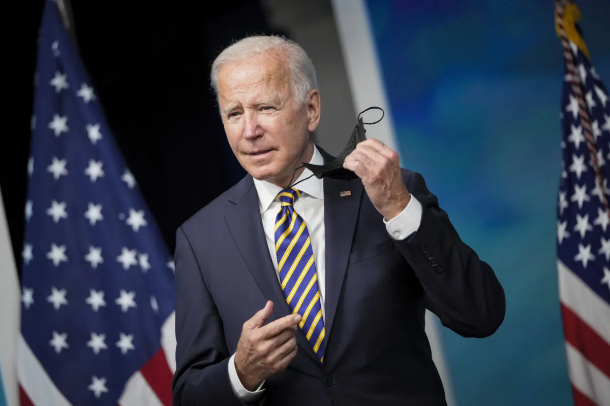 President Joe Biden removes his face mask as he arrives to speak in the South Court Auditorium on the White House campus on Oct. 14, 2021. (Drew Angerer/Getty Images)
