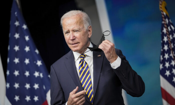 President Joe Biden removes his face mask as he arrives to speak in the South Court Auditorium on the White House campus on Oct. 14, 2021. (Drew Angerer/Getty Images)