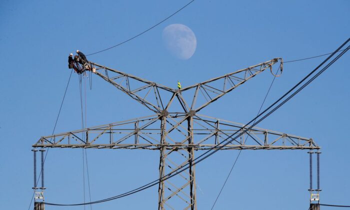 Electricians work atop a power pole near the lignite power plant in Neurath of German energy supplier and utility RWE, Germany. (Wolfgang Rattay/Reuters)